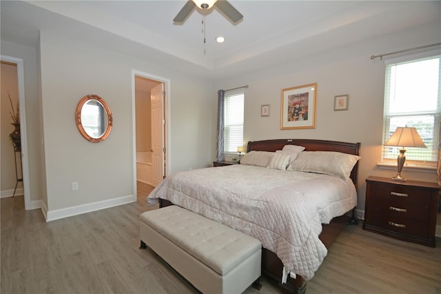 bedroom with ensuite bath, wood-type flooring, and ceiling fan