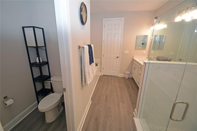 bathroom featuring vanity, toilet, hardwood / wood-style flooring, and walk in shower