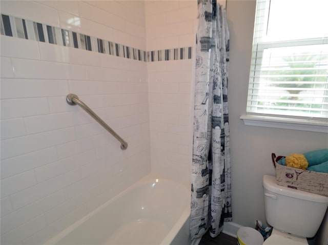 bathroom featuring shower / bath combination with curtain and toilet