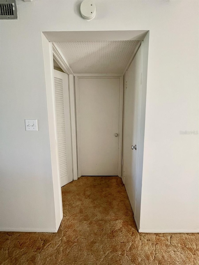 hallway with visible vents and carpet flooring