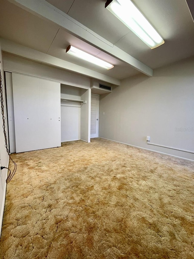 unfurnished bedroom with carpet and beam ceiling