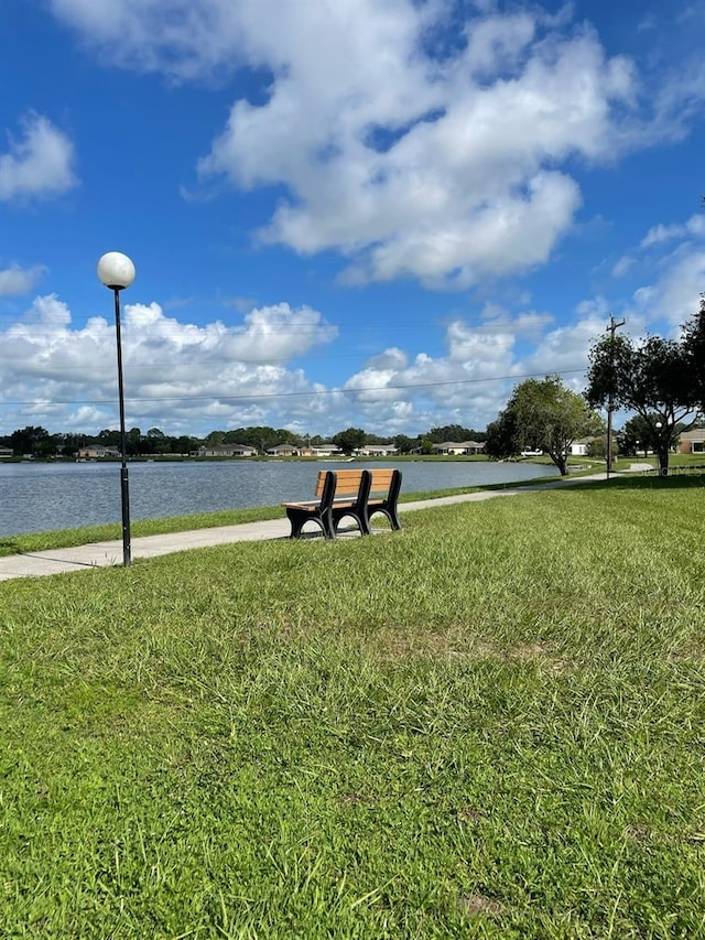 surrounding community with a yard and a water view