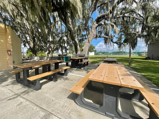 surrounding community with a lawn and outdoor dining area