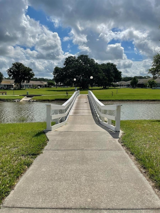 view of property's community with a yard and a water view