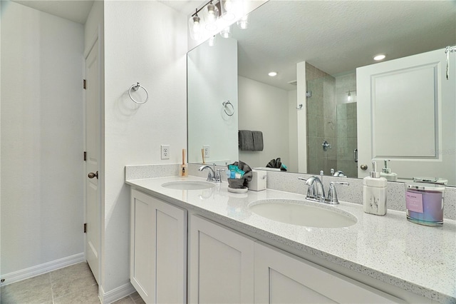 bathroom featuring tile patterned flooring, a shower with door, a textured ceiling, and vanity