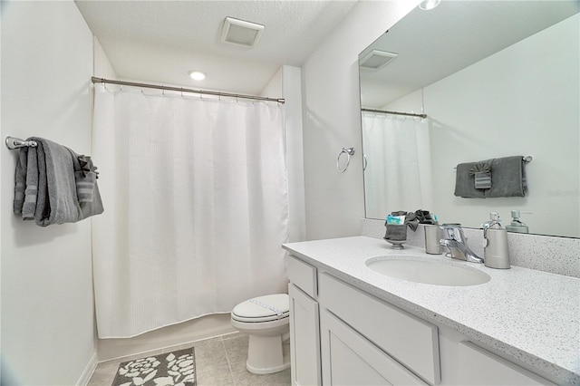 bathroom with tile patterned floors, toilet, a textured ceiling, and vanity