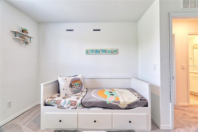 bedroom with a textured ceiling and light carpet