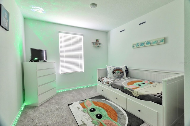 bedroom featuring light carpet and a textured ceiling