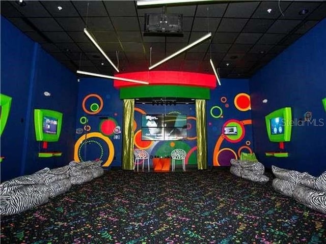 playroom featuring carpet flooring and a drop ceiling