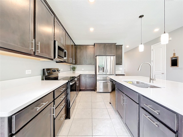 kitchen with sink, hanging light fixtures, an island with sink, stainless steel appliances, and light tile patterned floors