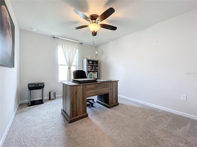 carpeted office space featuring a textured ceiling and ceiling fan