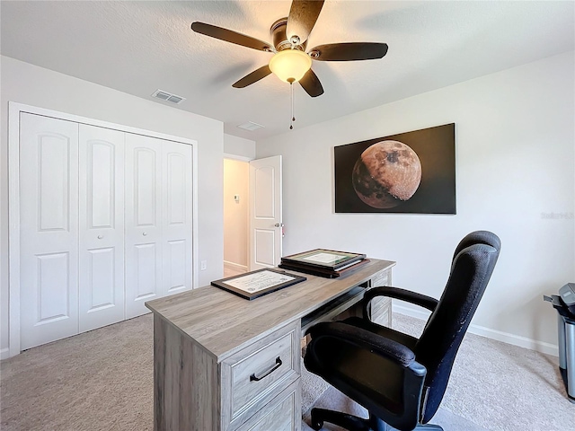 carpeted office space featuring ceiling fan