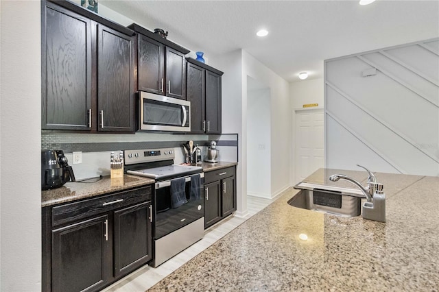 kitchen with appliances with stainless steel finishes, tasteful backsplash, and sink