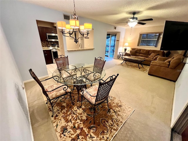 carpeted dining space with ceiling fan with notable chandelier and a textured ceiling