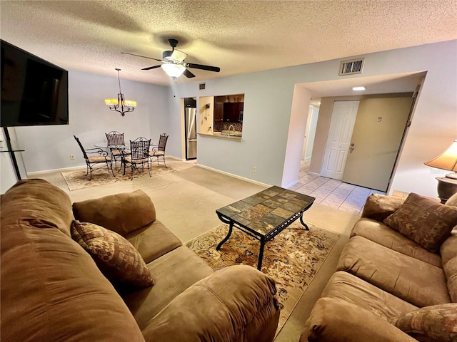 tiled living room featuring a textured ceiling, ceiling fan, and sink