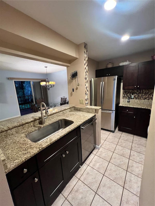 kitchen with backsplash, light tile patterned floors, decorative light fixtures, stainless steel appliances, and sink