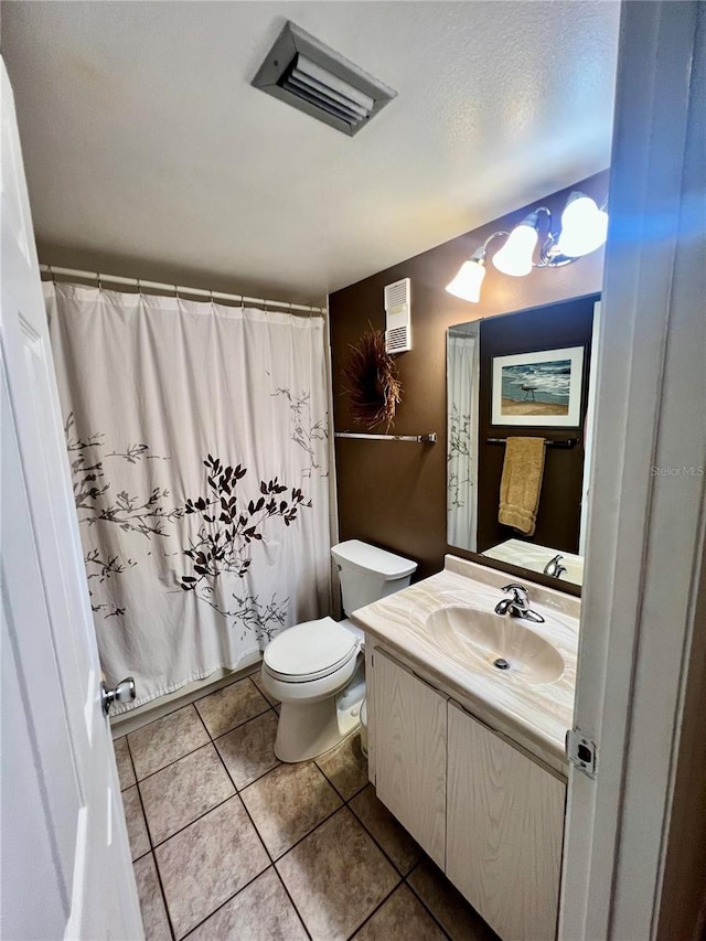 bathroom featuring curtained shower, tile patterned floors, toilet, vanity, and a textured ceiling