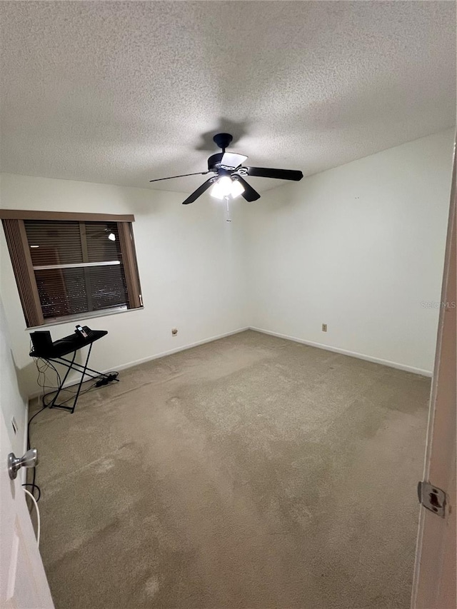 carpeted spare room with a textured ceiling and ceiling fan