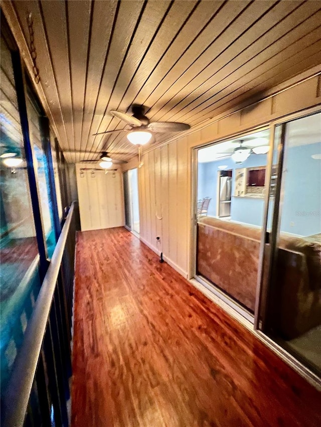 hall featuring wood walls, wood ceiling, hardwood / wood-style flooring, and a wealth of natural light