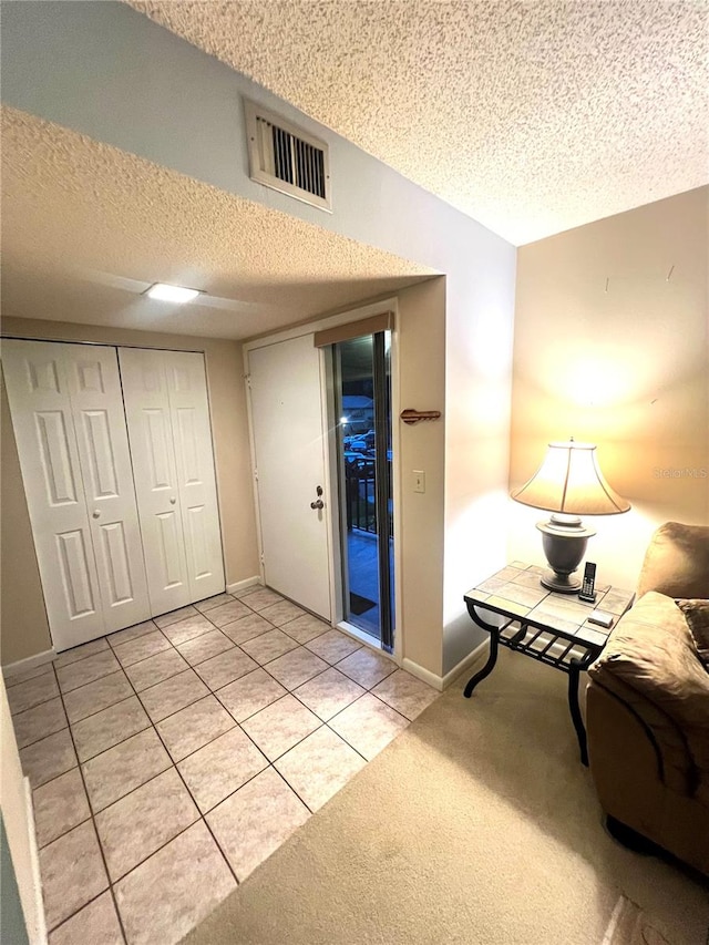 interior space featuring a textured ceiling and light tile patterned flooring