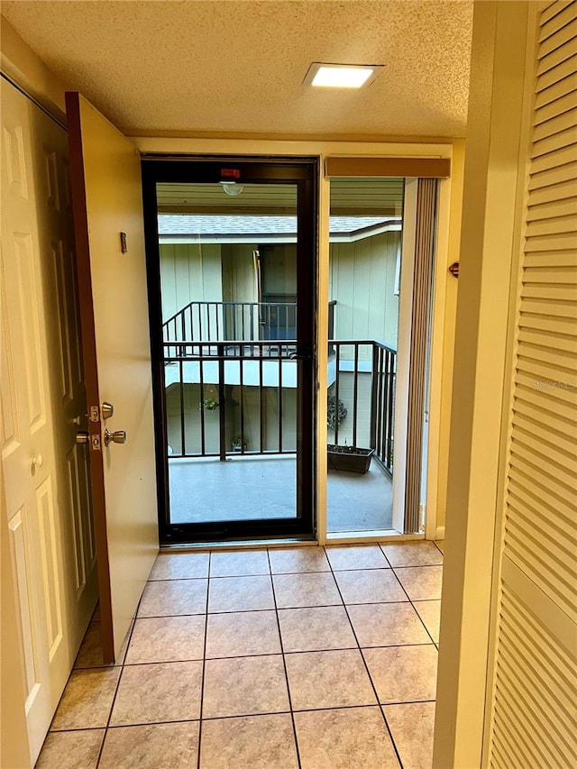 entryway featuring light tile patterned floors and a textured ceiling