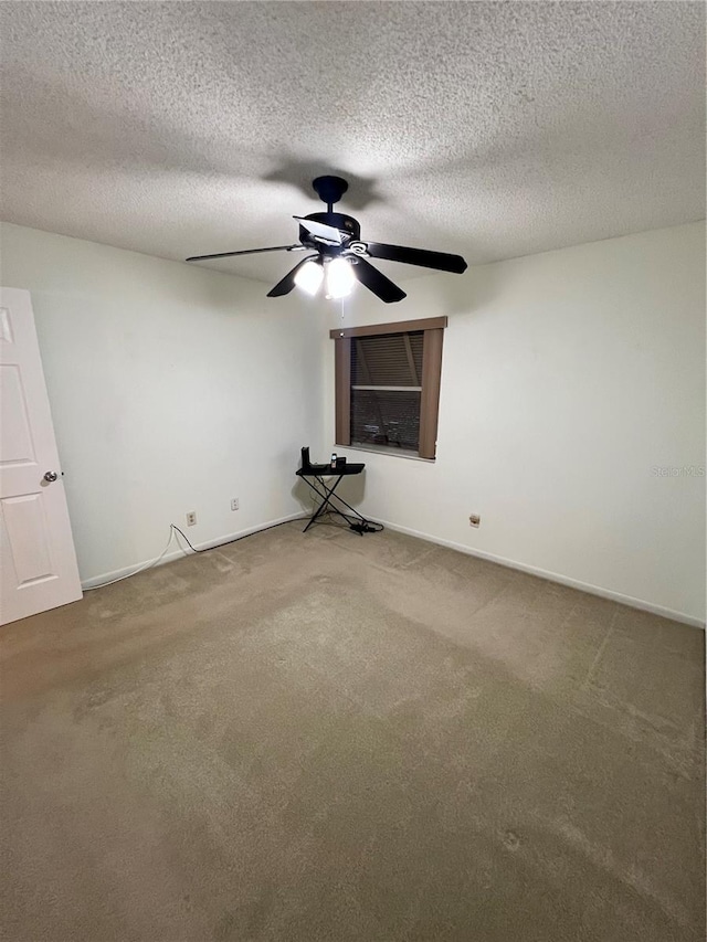 interior space with carpet flooring, ceiling fan, and a textured ceiling