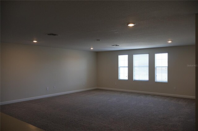 carpeted empty room with a textured ceiling