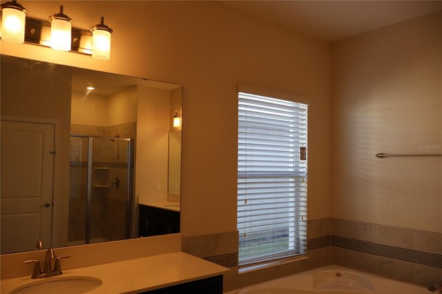 bathroom featuring shower with separate bathtub and vanity