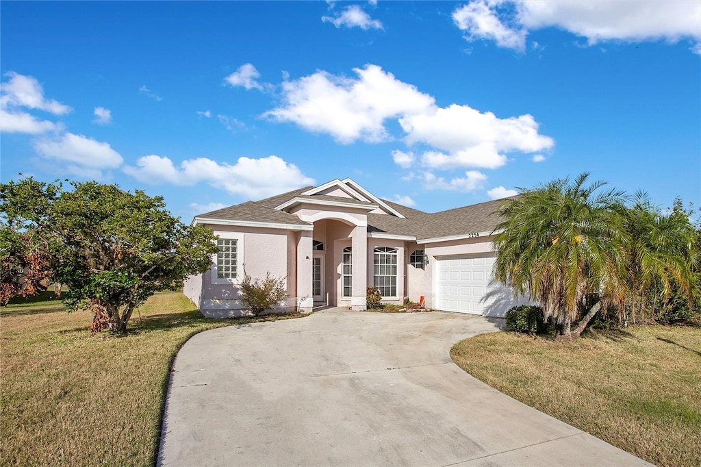 ranch-style house featuring a front lawn and a garage