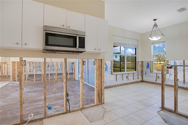 kitchen with white cabinetry, light tile patterned floors, and decorative light fixtures