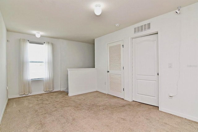 unfurnished bedroom featuring light carpet