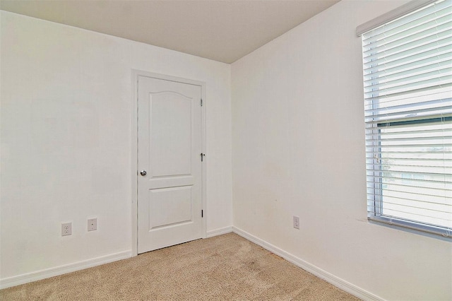 spare room featuring light colored carpet