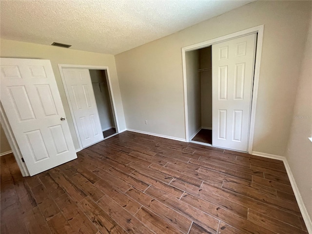 unfurnished bedroom featuring dark wood-type flooring and a textured ceiling