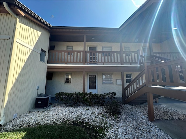 rear view of property featuring central AC unit and a balcony