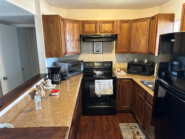 kitchen with a textured ceiling, black appliances, backsplash, and dark wood-type flooring