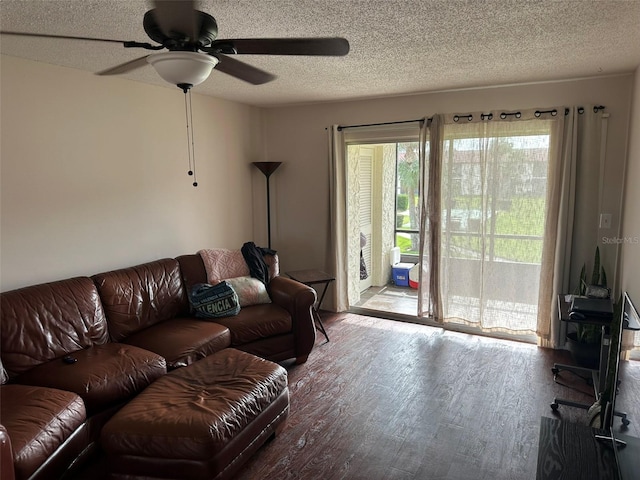 living room with ceiling fan, hardwood / wood-style flooring, and a textured ceiling