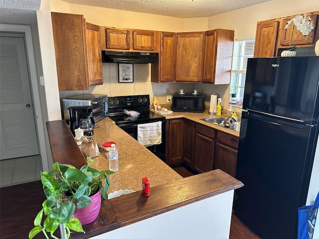 kitchen with a textured ceiling, black appliances, dark hardwood / wood-style floors, and sink