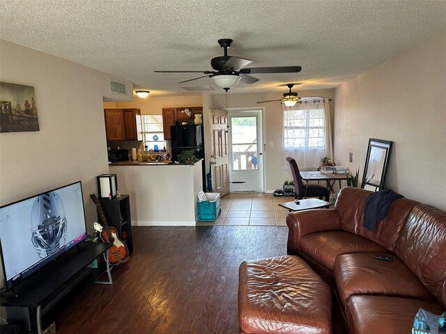 living room with light wood-type flooring, a textured ceiling, and ceiling fan