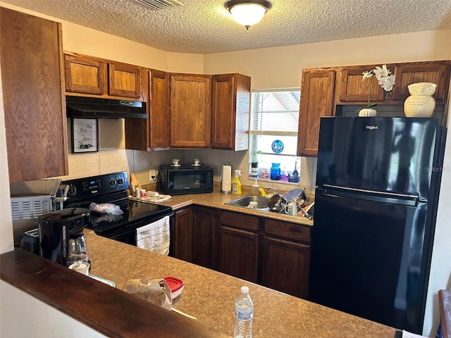 kitchen featuring a textured ceiling, black appliances, and sink