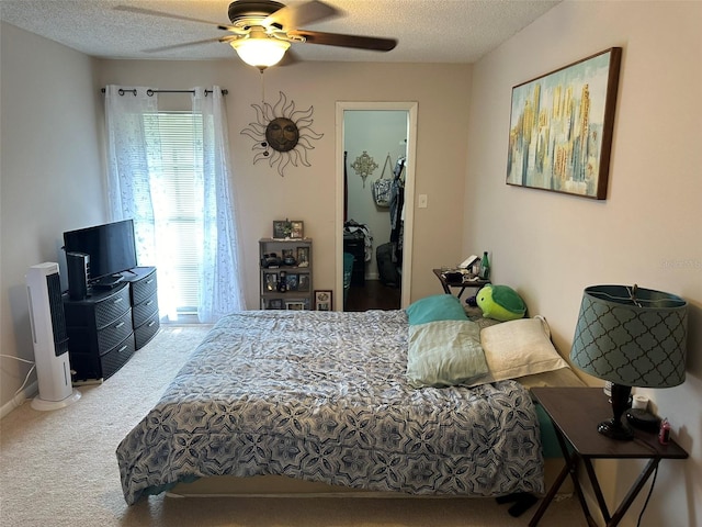 carpeted bedroom with a textured ceiling and ceiling fan