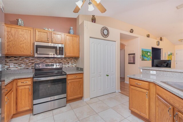 715 Unabelle Ave, Daytona Beach, FL 32117 - kitchen featuring ceiling fan, light tile patterned floors, lofted ceiling, and appliances with stainless steel finishes