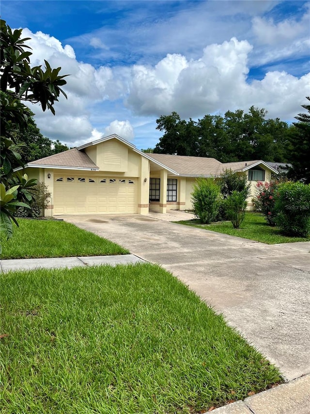 ranch-style home with a garage and a front lawn