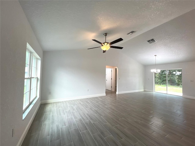 unfurnished room with dark hardwood / wood-style floors, a textured ceiling, ceiling fan with notable chandelier, and vaulted ceiling