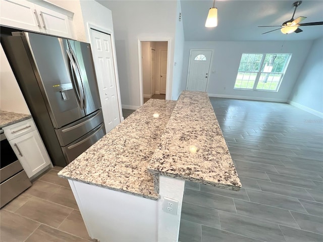 kitchen featuring hardwood / wood-style floors, appliances with stainless steel finishes, pendant lighting, and white cabinets