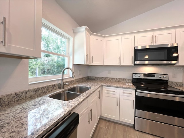 kitchen featuring lofted ceiling, sink, white cabinets, and stainless steel appliances