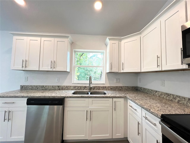 kitchen featuring light stone countertops, sink, appliances with stainless steel finishes, and white cabinets