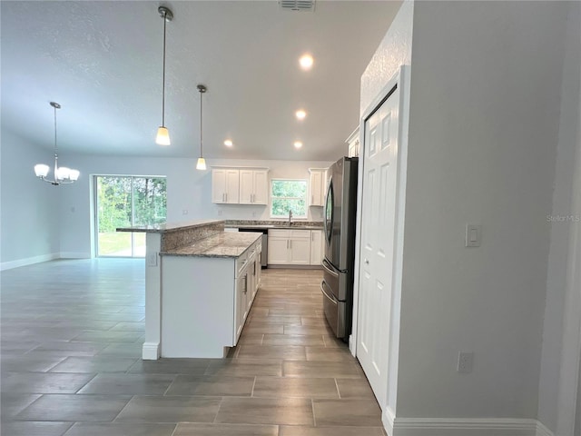 kitchen featuring white cabinets, pendant lighting, a healthy amount of sunlight, and stainless steel appliances