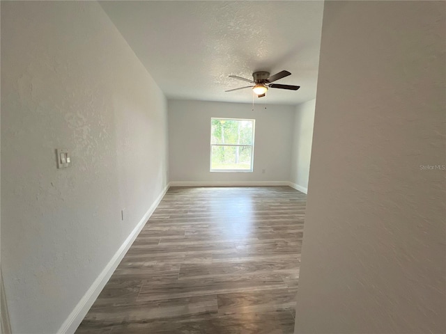 spare room with ceiling fan, a textured ceiling, and dark hardwood / wood-style flooring