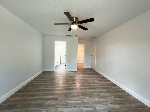 unfurnished room with ceiling fan, dark wood-style flooring, and baseboards