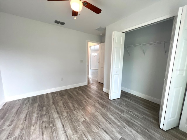 unfurnished bedroom featuring a closet, ceiling fan, and dark hardwood / wood-style flooring